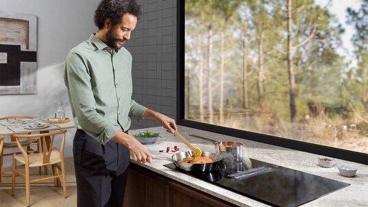 Man cooking in a modern kitchen with a view