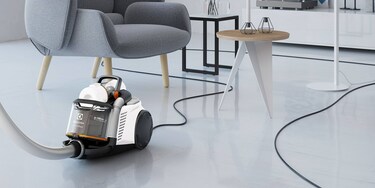 Një person që përdor kordonin ekstra të gjatë të Electrolux UltraFlex AnimalCare për të pastruar me lehtësi një dhomë ndenjeje