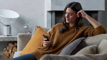 Woman sitting in sofa with phone